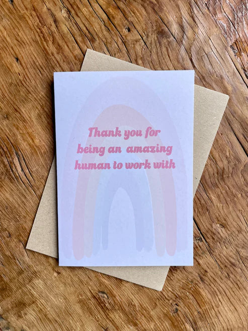 Greeting card with 'Thank you for being an amazing human to work with' text on a wooden surface